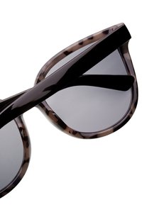 Kilpikonnakuosiset aurinkolasit, joissa on puoliksi läpinäkyvä musta kehys, harmaat linssit ja tyylikkäät templet; kaareva muoto ja kiiltävä pinta.