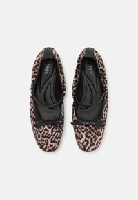 Leoparda raksta baleta kurpes ar mīkstu teksturētu virsu, melnu elastīgu ielikni un loku detaļu pie pirksta. Melna oderējums un logotips iekšpusē.