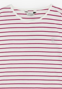 Bílá košile s horizontálními tmavě růžovými pruhy, kulatým výstřihem a malým rhinestone lebkovým emblémem na levé hrudi.