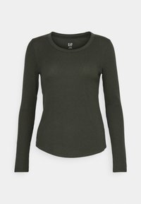 Långärmad ribbad t-shirt i mörk olivgrön med rund halsringning och rundad nederkant. Tillverkad av mjukt, texturerat tyg.