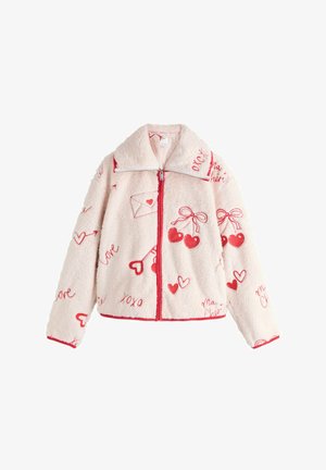 Rózsaszín polárdzseki magas gallérral, piros díszítésekkel és egész felületén mintákkal, beleértve szíveket, cseresznyéket és borítékokat. Elől cipzáros rögzítés.