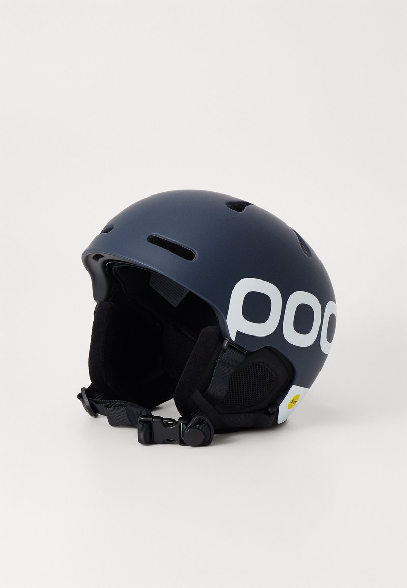 Ski-hjelm i matt marineblå med hvit logo, har flere ventilasjonsåpninger, myk innvendig polstring og justerbar stropp for sikker passform.