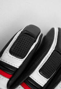 Guanti in pelle nera con accenti bianchi, dotati di sezioni perforate e dettagli a strisce rosse, che evidenziano un design e una texture eleganti.