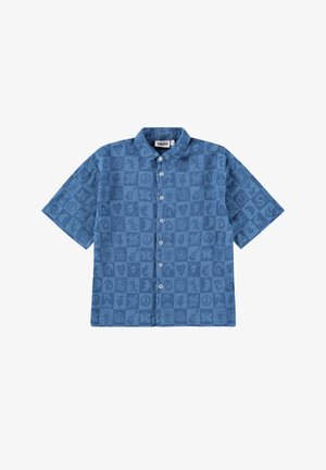 Chemise à manches courtes, en tissu bleu, avec un motif en grille comportant divers symboles et designs. Col classique et poignets unis.