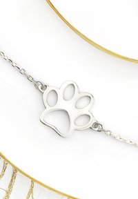 Bracciale in argento con pendente a forma di impronta di zampa ritagliata. L'impronta di zampa presenta forme arrotondate, una texture liscia e una finitura lucida.