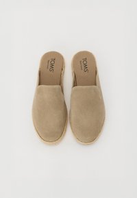 Beige zamšādas slaidi kurpes ar apaļu purngalu, teksturētu virsu un dabīgu jutu zoli. Iekļauta mīksta kāju gulta ar izcelto zīmola logo.