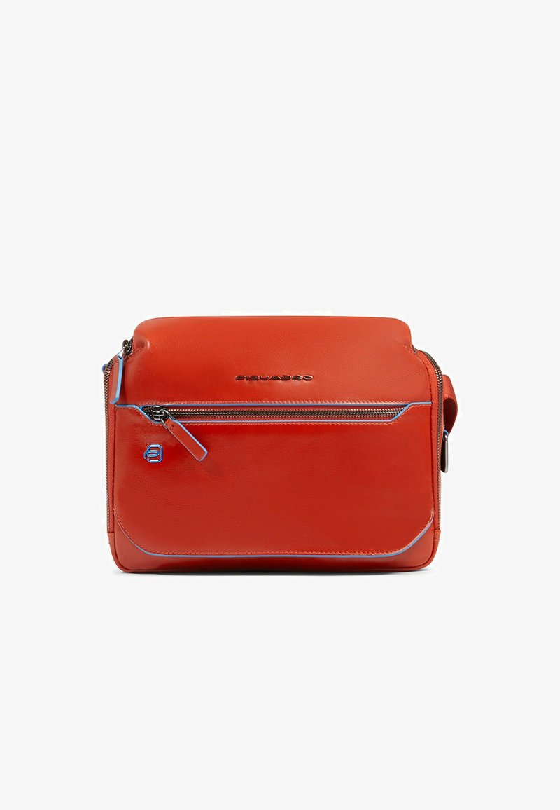 Bolso bandolera de cuero rojo con textura lisa, que cuenta con un bolsillo frontal con cremallera, detalles en azul y logo grabado. Diseño rectangular compacto.