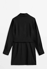 Robe noire à manches longues avec un col à revers, une coupe décontractée et des poignets boutonnés. Tissu lisse avec une coupe mi-longue et un empiècement au dos.