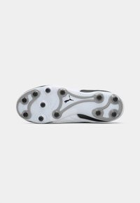 White and black soccer cleat sole with textured pattern, circular studs, and a prominent logo. Rubber material with a sleek design.