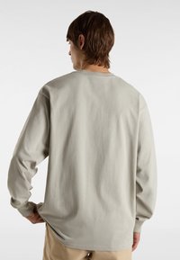 Lange mouwen t-shirt in lichtgrijs katoen, met een ontspannen pasvorm, ronde hals en ribbelmanchetten, gezien vanuit de achterkant.