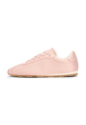 Jasnoróżowy sneaker z zapięciem na sznurowadła, białą podszewką i jasno-brązową gumową podeszwą, widoczny z boku na białym tle.