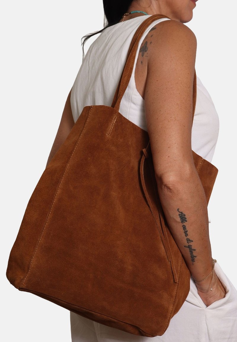 Borsa a tracolla in suede marrone con una texture morbida, design spazioso e lunghe tracolle. Presenta una cucitura minimale e una silhouette semplice.