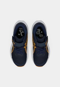 Ναυτικές αθλητικές παπούτσια με πορτοκαλί λεπτομέρειες, πλέγμα επάνω μέρος, υφή επιφάνειας, κορδόνια και ρυθμιζόμενη ζώνη. Λαστιχένια σόλα με λεπτομερή εσωτερικό σχεδιασμό.