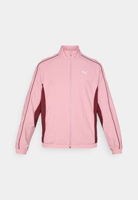 Ljust rosa zip-up jacka med vinröda sidopaneler och vitt logotyp. Tillverkad av ett slätt, lätt material med ribbade muddar.