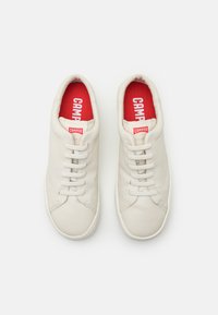 Sneakers bianchi in pelle con una superficie liscia, dotati di sei fori per i lacci, punta arrotondata e soletta rossa con la scritta "CAMPER".