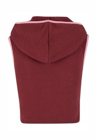 Burgunderfarget ermeløs hettegenser med rosa kant, laget av myk stoff. Har en rund hette og en rett søm nederst.