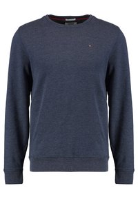 Námořnický crewneck svetr vyrobený z měkkého materiálu, s dlouhými rukávy a žebrovanými manžetami. Malá vyšívaná nášivka na hrudi.