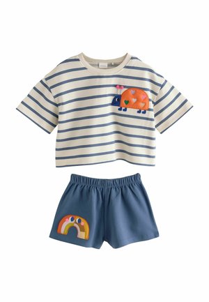 Kaksiosainen puuvillapuku, jossa on raidallinen lyhythihainen toppi, jossa on leppäkerttu-applikaatio, ja yksiväriset siniset shortsit, joissa on sateenkaari-applikaatiokoristelu.