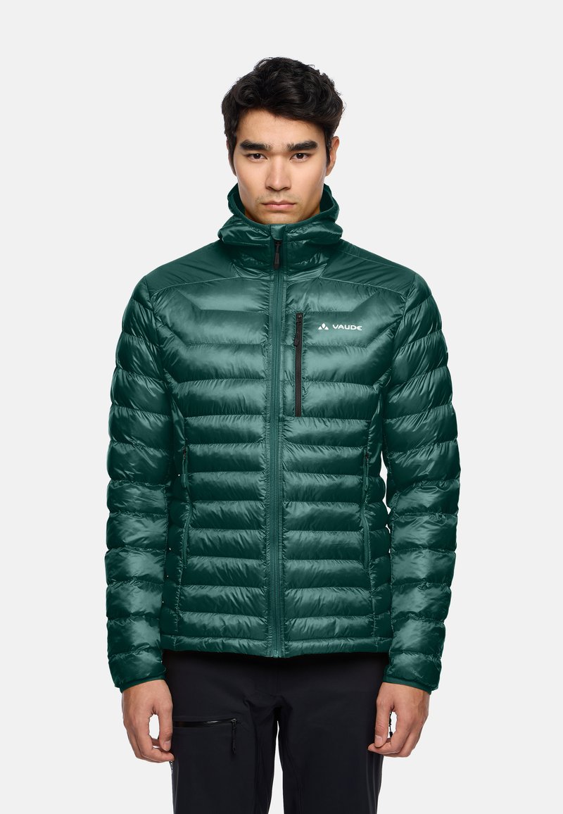 Giacca a vento verde isolata con design a rombi orizzontali, colletto alto, zip frontale e una piccola tasca sul petto con zip.