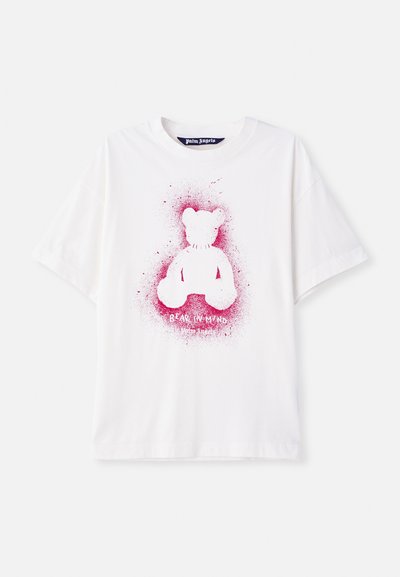 Balta medvilninė marškinė su rožinės spalvos meškino grafika centre ir tekstu "BEAR IN MIND" apačioje. Trumpi rankovės, laisvas siluetas.