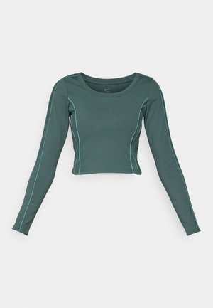 Crop top à manches longues en tissu bleu sarcelle foncé avec des coutures contrastantes bleu clair. Présente un col rond et un design ajusté.
