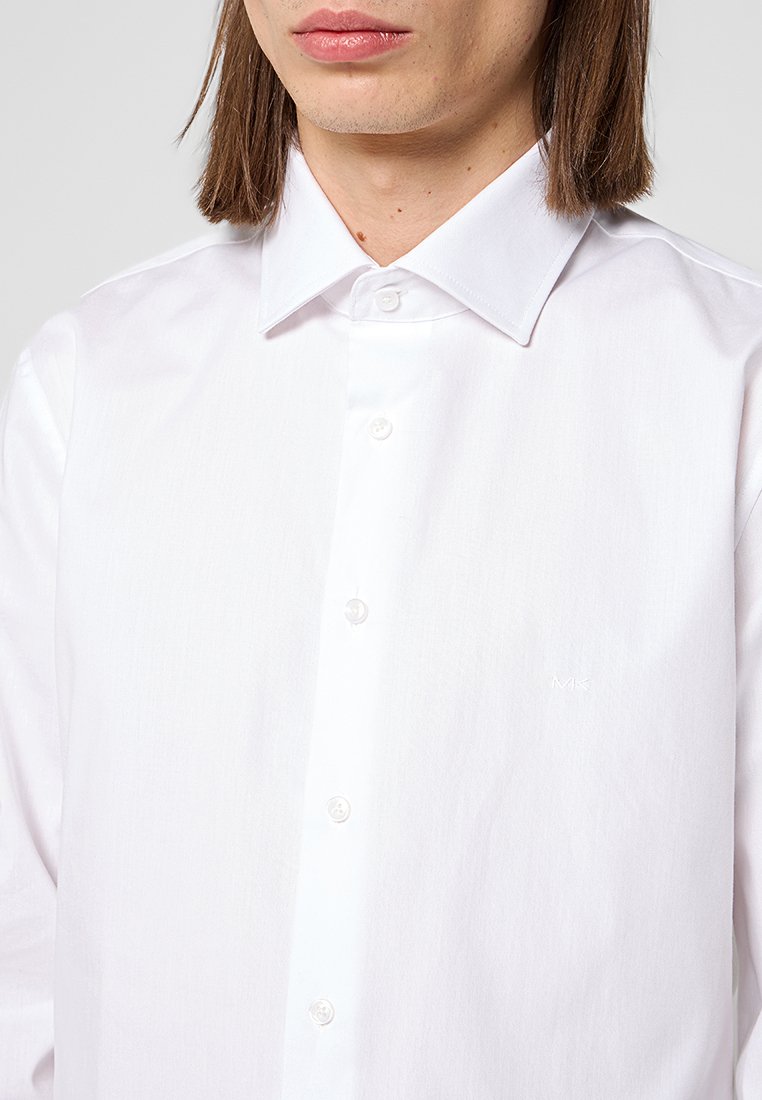 Weißes Hemd mit Knöpfen aus glattem Stoff, ausgestattet mit einem klassischen Kragen, fünf Knöpfen und einem dezenten Logo, das links aufgestickt ist.
