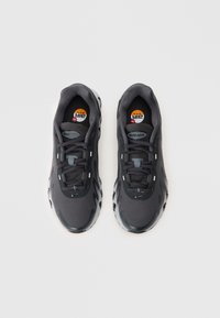 Par tenisica Nike Air Max tamnosive boje s crnim vezicama, mrežastim i sintetičkim gornjim dijelom, vidljivim jastučićem, prikazane od gore na bijeloj pozadini.