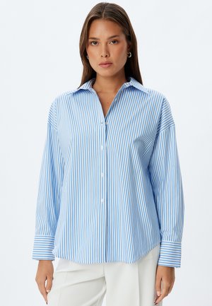 Light blue and white striped long-sleeve shirt with a button-down collar, featuring a relaxed fit and buttoned cuffs.