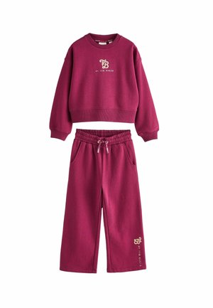Maroon sweatshirt and matching joggers, made of soft fabric. Sweatshirt has ribbed cuffs and a logo; joggers feature an elastic waistband and pockets.