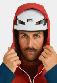 White climbing helmet with ventilation holes; red hooded jacket with blue sleeves; zipper detail; male figure adjusting hood.
