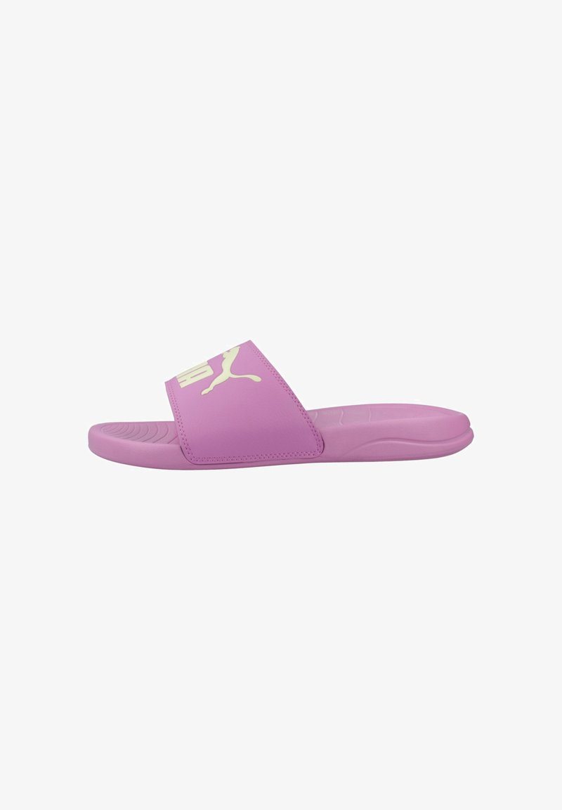 Sandale à glissière violette avec semelle rembourrée et large bride arborant un logo Puma blanc, vue de côté sur fond blanc.
