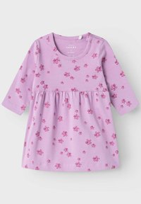 Abito a maniche lunghe di colore lilla realizzato in cotone morbido, con vita arricciata e motivi floreali rosa sparsi.