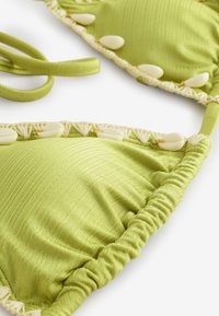Top de bikini verde cu textură adunată, cupe triunghiulare și o margine decorativă cu accente albe de scoici și bretele asortate.