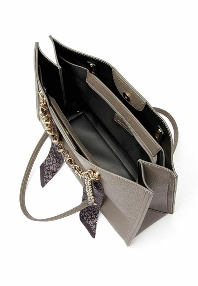 Borsa a mano in pelle grigia con superficie testurizzata, catena dorata come dettaglio hardware e interno nero. Include accenti in tessuto decorato sulle maniglie.