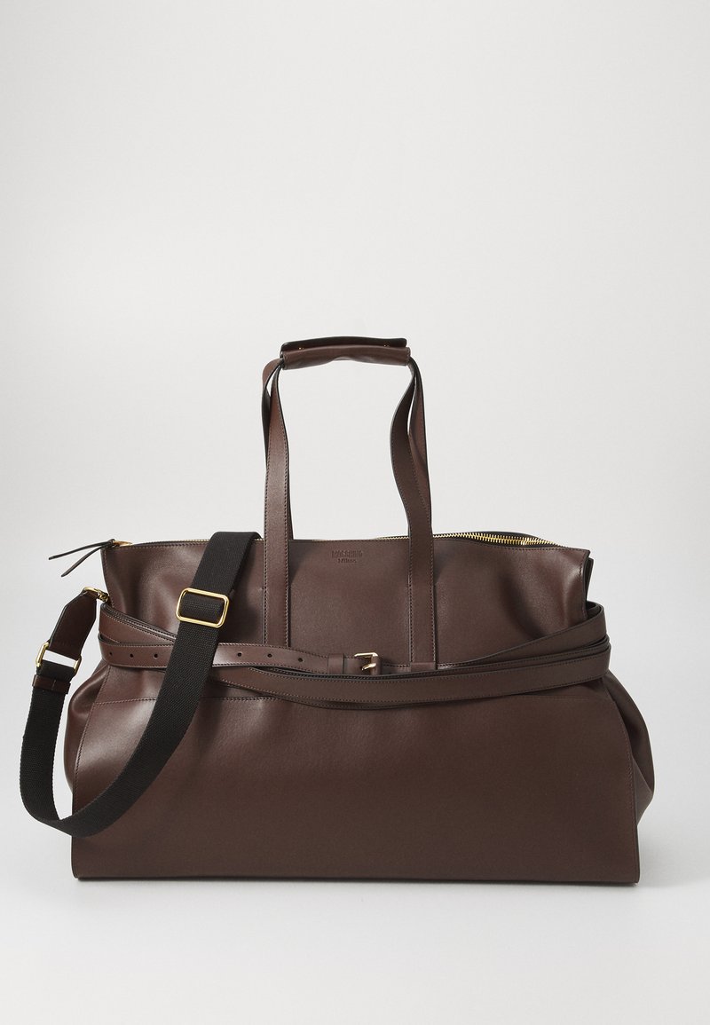Large brown leather duffel bag with dual handles, adjustable black shoulder strap, and gold-tone zipper and buckle details.