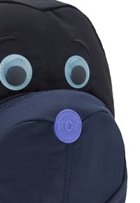 Zaino Kipling con design nero e blu, grandi occhi blu in plastica e una patch con logo viola sulla tasca frontale. Tessuto testurizzato.