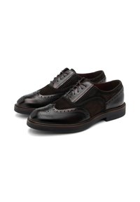 Scarpe eleganti in pelle e suede marrone con dettagli brogue, punte rotonde e suola piatta, dotate di lacci e texture a contrasto.