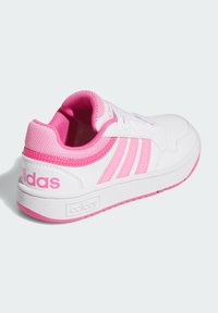 Weißer Sneaker mit pinkfarbenen Akzenten, ausgestattet mit einer glatten, lederähnlichen Oberfläche, einer Mesh-Zunge und drei charakteristischen Streifen. Gummisohle mit strukturiertem Grip.