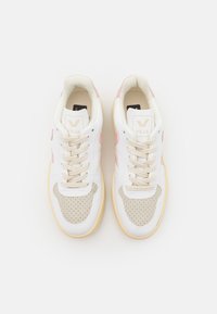 Sneaker bianche con dettagli rosa e sezioni perforate color beige. Punta arrotondata, chiusura a lacci piatta e suola in gomma con finitura testurizzata.