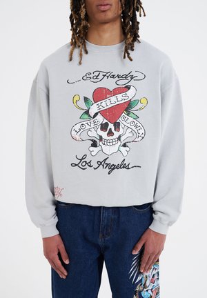 Gray sweatshirt featuring a colorful graphic with a skull, heart, and text "Love Kills Slowly" and "Los Angeles." Long sleeves, relaxed fit.