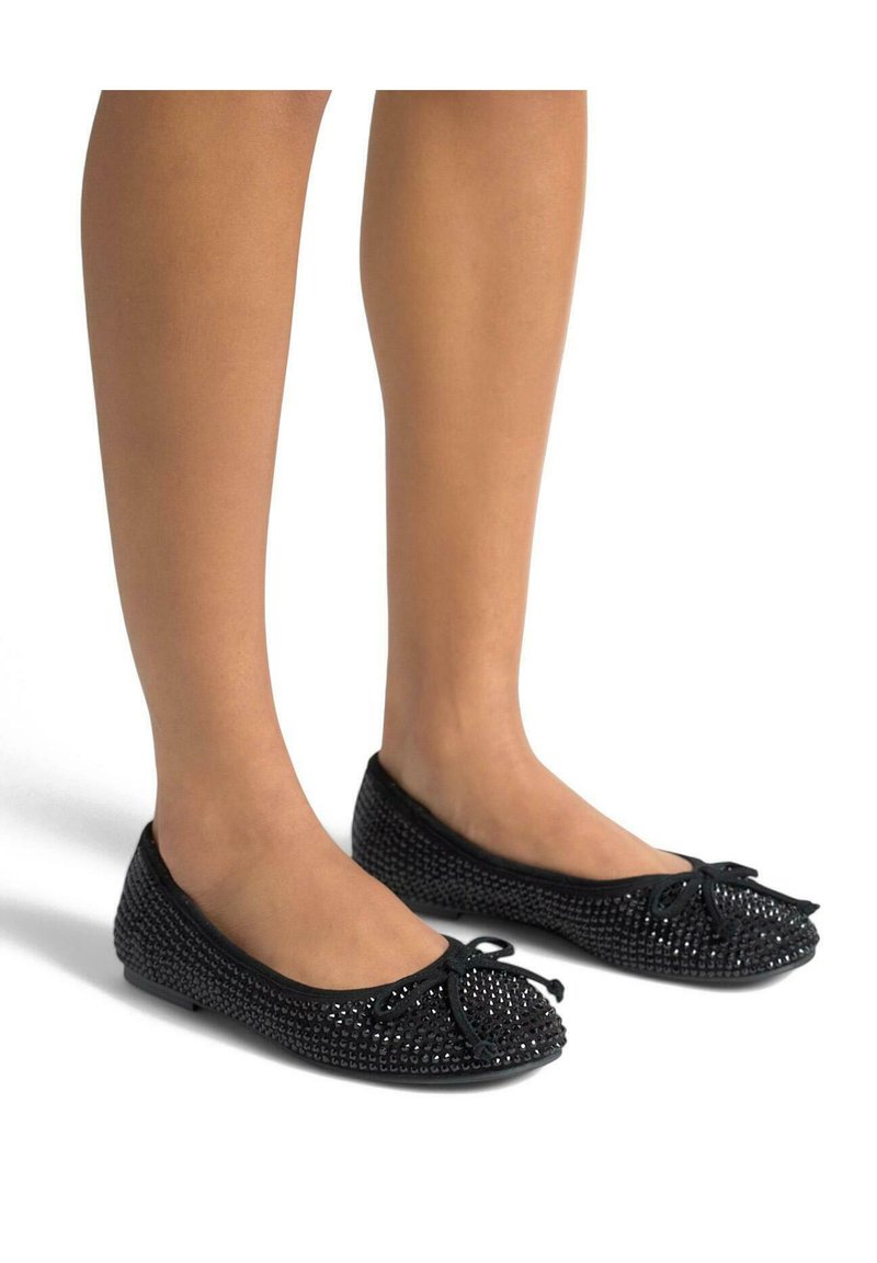 Ballerines noires avec un motif tissé, bout rond et petit nœud sur le devant. Matériau doux, semelle plate et design flexible.