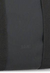 Borsa impermeabile nera realizzata in materiale gommoso. Presenta una texture liscia e cinturini elastici. Include un dettaglio con il logo "RAINS" in rilievo.