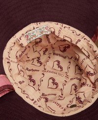 Bucket hat met een bordeaux corduroy buitenkant. De binnenkant heeft een lichtbeige voering met herhaalde patronen van harten en merklogo's.