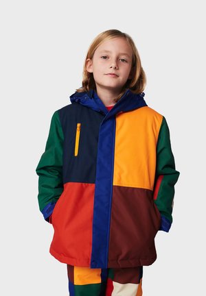 Chaqueta multicolor que presenta secciones de color naranja, marino, verde y marrón. Hecha de un material suave y resistente al agua, con capucha y bolsillo con cremallera.
