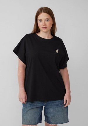 Zwarte katoenen T-shirt met een relaxte pasvorm, korte mouwen en een klein geborduurd ontwerp op de borst. Draagt het met denim shorts.