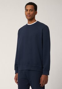 Dunkelblaues Sweatshirt aus Baumwollmischung, mit Rundhalsausschnitt, gerippten Bündchen und Saum, sowie einem kleinen Logo auf der Brust, glatte Textur.