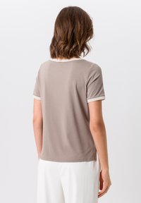 Korte mouw bruin T-shirt met een ronde halslijn, gedetailleerd met witte gestreepte accenten op de mouwen en de kraag, gemaakt van een soepele stof.
