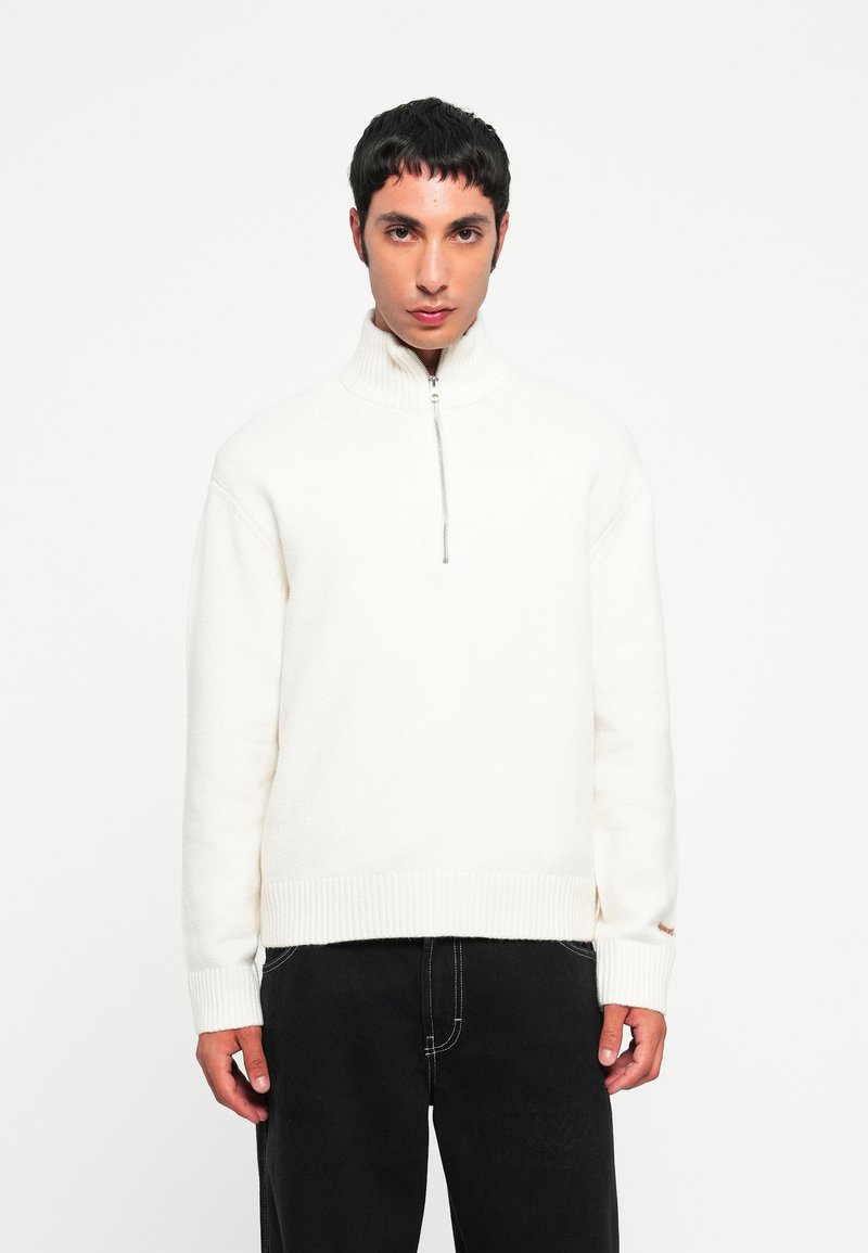 Biela fleece polovičná mikina so zúženými manžetami a lemom. Mäkká textúra, uvoľnený strih a minimalistický design so strieborným zipsom.