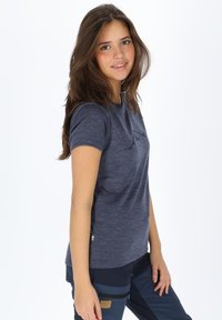 T-paita, jossa on lyhyet hihat ja tummansininen väri, jossa on hienovarainen logopainatus rinnassa. Valmistettu kevyestä, tekstuuritetusta kankaasta.