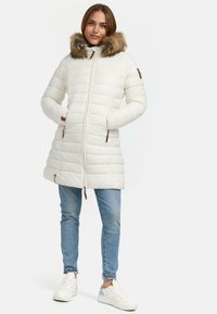 Lightweight white puffer coat with a fur-trimmed hood, vertical quilted design, two side pockets, and brown accents on the zippers.